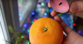 Прикладываем свечу к хвостику апельсина
