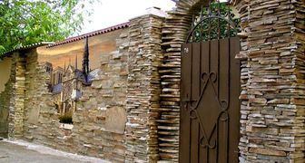 Декоративный забор для сада из камня создает впечатление надежности и комфорта