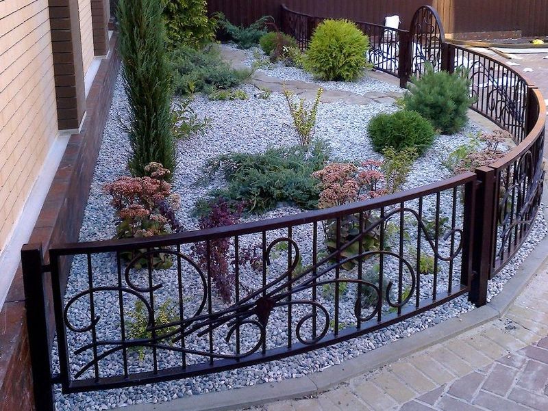 Кованный декоративный забор для сада выглядит опрятно и изысканно