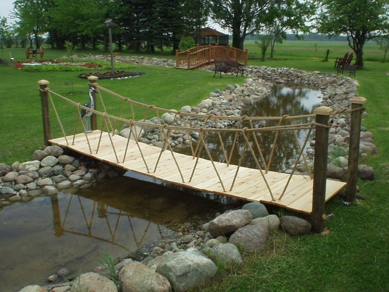 Перекидной мост через ручей в саду