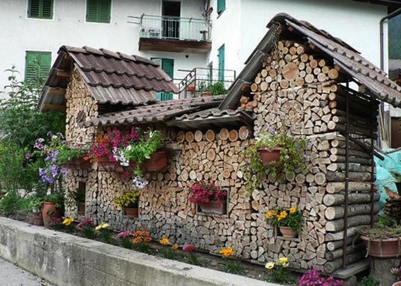Поленница в виде дома с крышей украшенная цветами